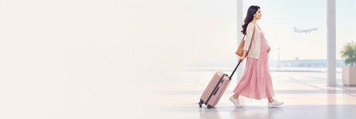 The Pros and Cons of Traveling When Pregnant - The Wise Traveller - Pregnant woman walking in the airport