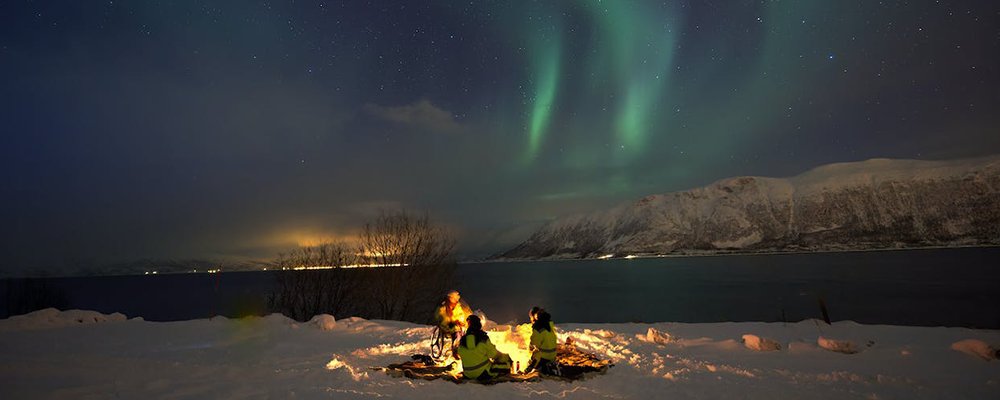 Navigating Health and Safety for Winter Camping and Hiking - The Wise Traveller - Camp fire and northern lights