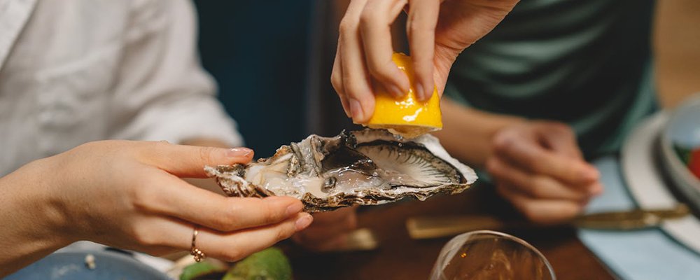 Oysters of the World on a Plate - The Wise Traveller - Lemon juice on oyster