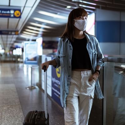 Should You Travel This Year? Questions You Should Ask Before Booking a Trip - The Wise Traveller - Mask and luggage