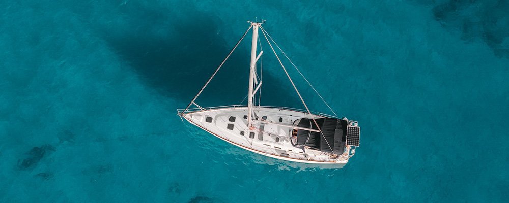 The Ultimate Solo Adventure - Traveling Abroad on Your Own Boat - The Wise Traveller - Single boat on blue sea